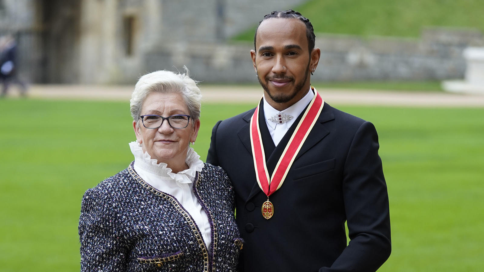 Lewis Hamilton with his mother Carmen Lockhart poses for the media after he was made a Knight Bachelor by Britain's Prince Charles during a investiture ceremony at Windsor Castle in Windsor, England, Wednesday, Dec. 15, 2021.