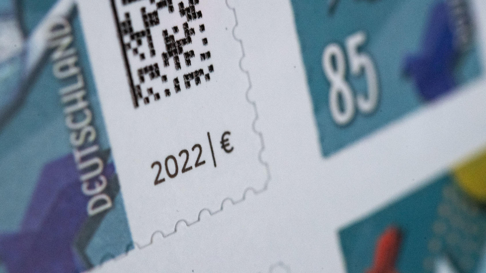 27.12.2021, Baden-Württemberg, Stuttgart: ILLUSTRATION - 85 Cent Briefmarken kleben auf einem Bogen. Zum 1. Januar steigt das Porto von Inlandsbriefen, der Standardbrief kostet zukünftig 85 Cent. Alte Marken bleiben gültig, es muss aber zusätzlich fr