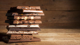 Chocolate blocks stack with different kind of chocolate on wooden background 