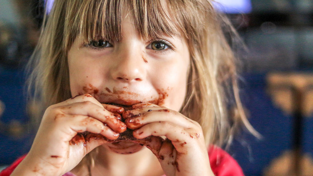 Kind mit verschmiertem Schokoladen-Gesicht
