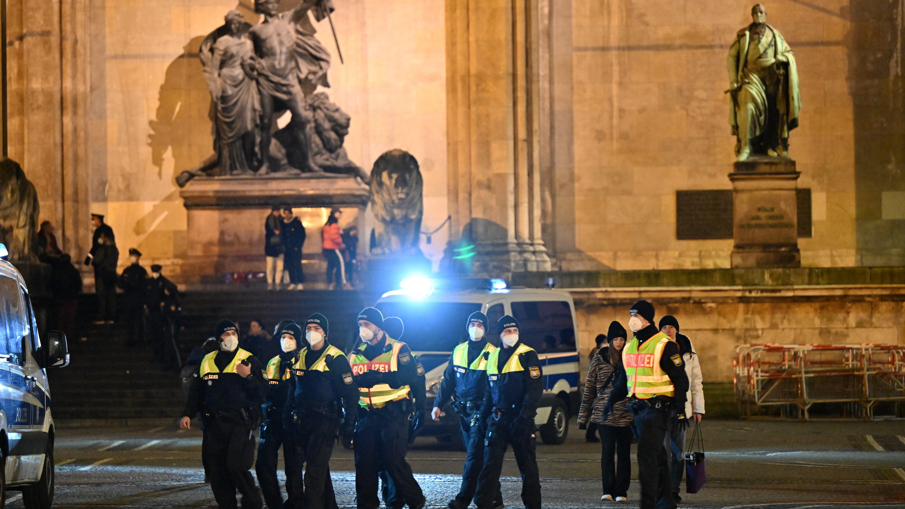 30.12.2021, Bayern, München: Einsatzkräfte der Polizei stehen auf dem Odeonsplatz vor der Feldherrnhalle, falls sich "Spaziergänger" versammeln sollten. Immer mehr bayerische Kommunen verbieten unangemeldete Versammlungen und «Spaziergänge» zum Prote