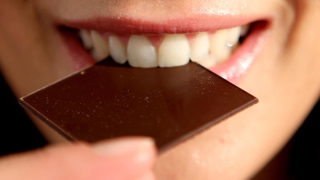 Woman eats a piece of chocolate