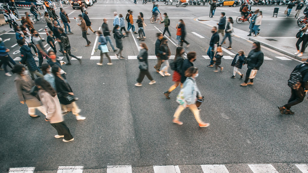 Eine Menschenmenge in der Stadt, alle tragen eine Mund-Nasenschutz-Maske, um sich gegen das Coronavirus zu schützen.