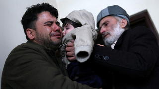 Hamid Safi, a 29-year-old taxi driver who had found baby Sohail Ahmadi in the airport, cries as he hands over Sohail to his grandfather Mohammad Qasem Razawi in Kabul, Afghanistan, January 8, 2022. Picture taken January 8, 2022. REUTERS/Ali Khara     TPX IMAGES OF THE DAY