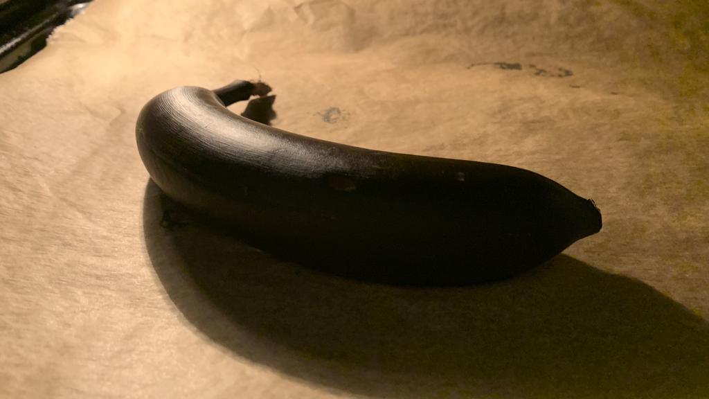 Eine braune Banane liegt auf einem Backblech.