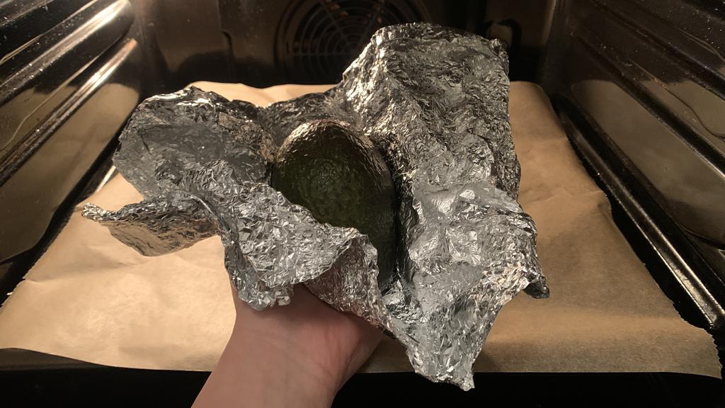 Eine Avocado eingewickelt in Alufolie im Ofen.
