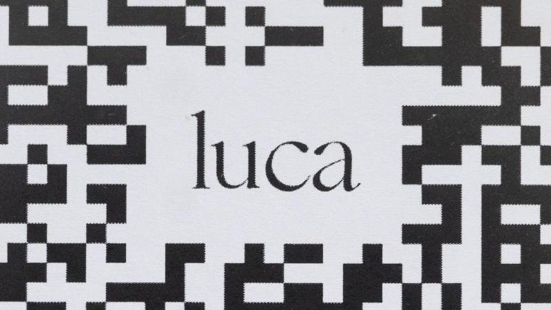 Ein Barcode, der mit der Luca-App gescannt werden kann, hängt in einem Geschäfts an einer Scheibe. Foto: Marijan Murat/dpa/Symbolbild