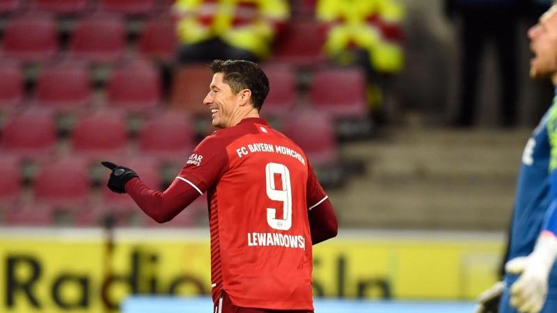 Münchens Robert Lewandowski (l) bejubelt sein Tor zum 0:4 neben Kölns Torhüter Marvin Schwäbe. Foto: Marius Becker/dpa