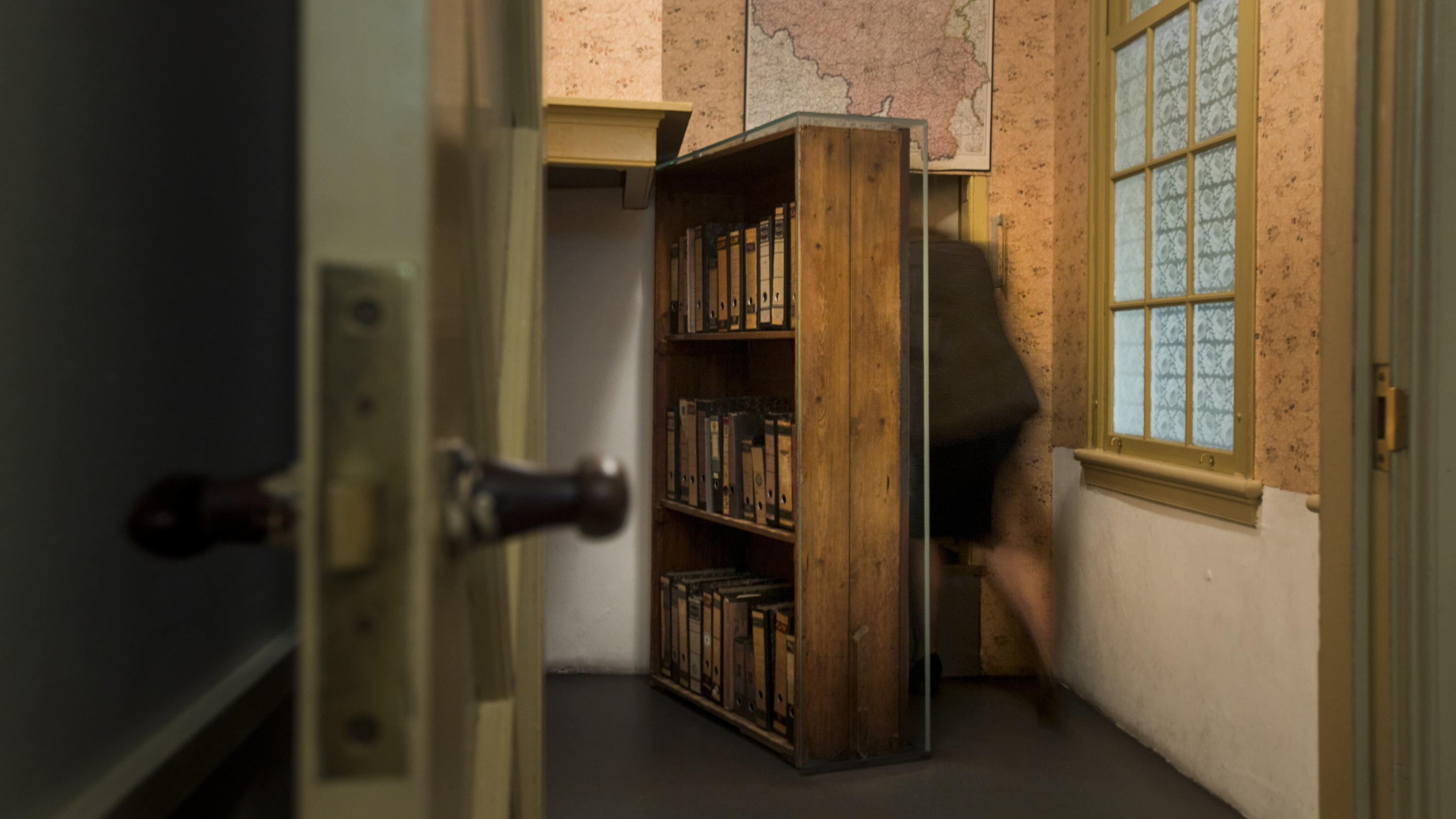 FILE- A woman enters the secret annex at the renovated Anne Frank House Museum in Amsterdam, Netherlands, Wednesday, Nov. 21, 2018. A cold case team that combed through evidence for five years may have solved one of World War II's enduring mysteries: