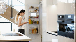 Frau steht vor smartem Kühlschrank