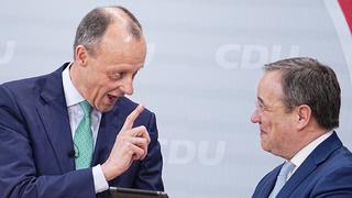 22.01.2022, Berlin: Friedrich Merz (l), Kandidat für das Amt des CDU Bundesvorsitzenden, überreicht dem scheidenden CDU-Bundesvorsitzenden Armin Laschet beim Bundesparteitag der CDU im Konrad-Adenauer-Haus ein iPad mit speziellen Apps. Beim 34. Parteitag der CDU soll Merz als neuer Bundesvorsitzender gewählt werden. Pandemiebedingt findet der Parteitag rein digital statt. Das Ergebnis der Wahl muss daher noch per Briefwahl bestätigt werden. Foto: Michael Kappeler/dpa +++ dpa-Bildfunk +++