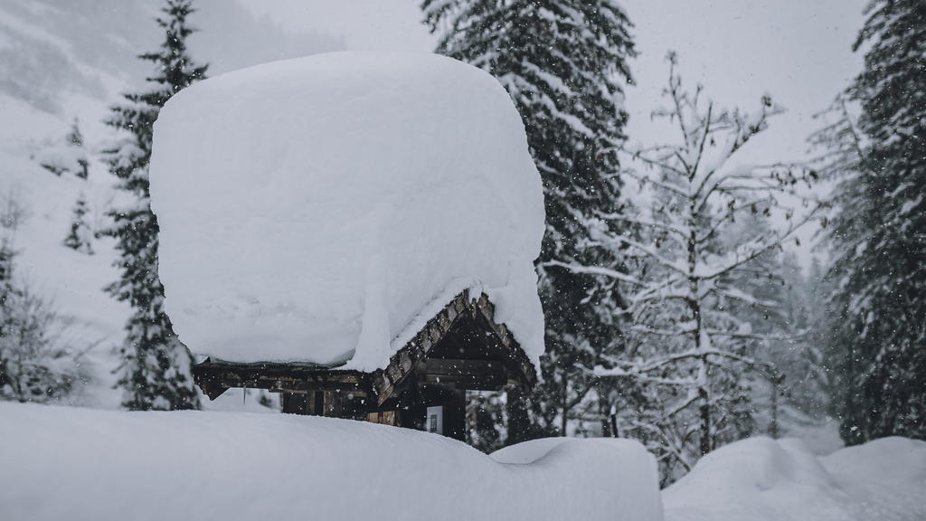 22.01.2022, Österreich, Leogang: Große Schneemengen liegen auf einem Dach. Foto: Expa/Stefanie Oberhauser/APA/dpa +++ dpa-Bildfunk +++
