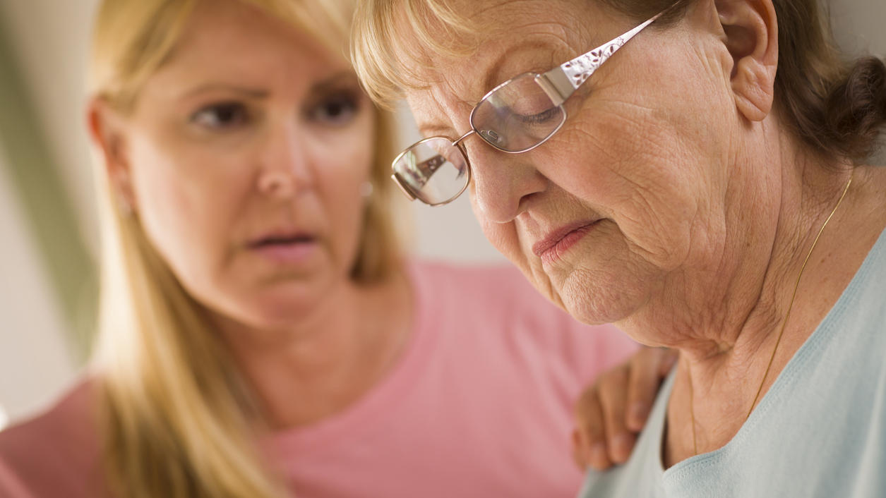 Young Adult Woman Consoles Sad Senior Adult Female.