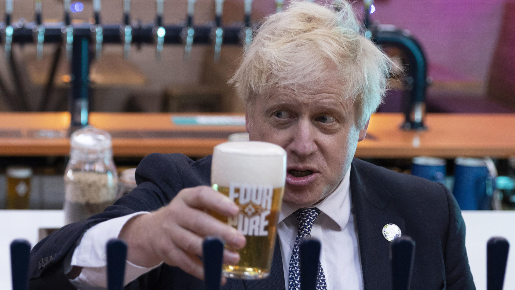 ARCHIV - 27.10.2021, Großbritannien, London: Boris Johnson, Premierminister von Großbritannien, hält bei einem Besuch in der Fourpure-Brauerei ein Bier in der Hand. Zum Feierabend auf zwei Pints in den Pub, das ist in Großbritannien seit langem für v