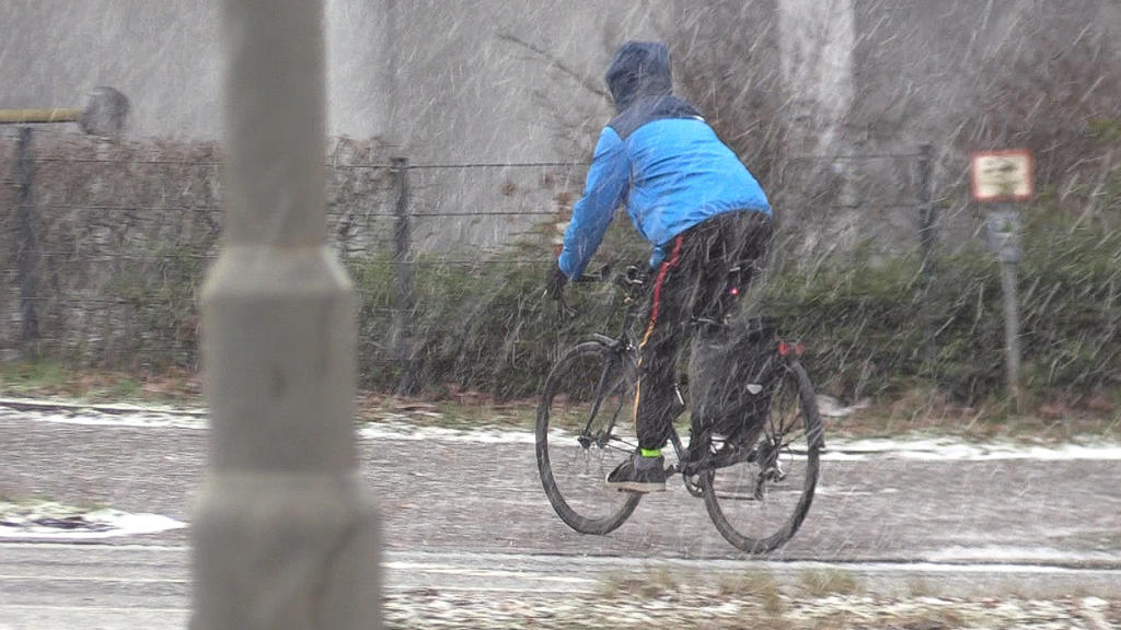 20.01.2022, Hamburg: Ein Fahrradfahrer fährt im dichten Schneeregen. Über dem Hamburger Stadtgebiet waren am Nachmittag teils starke Schnee- und Graupelschauer niedergegangen. Der Deutsche Wetterdienst warnte für Hamburg und Schleswig-Holstein im Bin