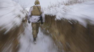 dpatopbilder - 27.01.2022, Ukraine, Luhansk: Ein ukrainischer Soldat geht an der Frontlinie durch einen Graben. Bei den massiven Spannungen zwischen Russland und dem Westen im Konflikt um die Ukraine ist auch nach den schriftlichen Antworten der USA und der Nato kein Ende in Sicht. Der Kreml ließ den Westen zunächst im Unklaren darüber, wie Russland im Ringen um Sicherheitsgarantien auf das Dialogangebot reagiert. Foto: Vadim Ghirda/AP/dpa +++ dpa-Bildfunk +++