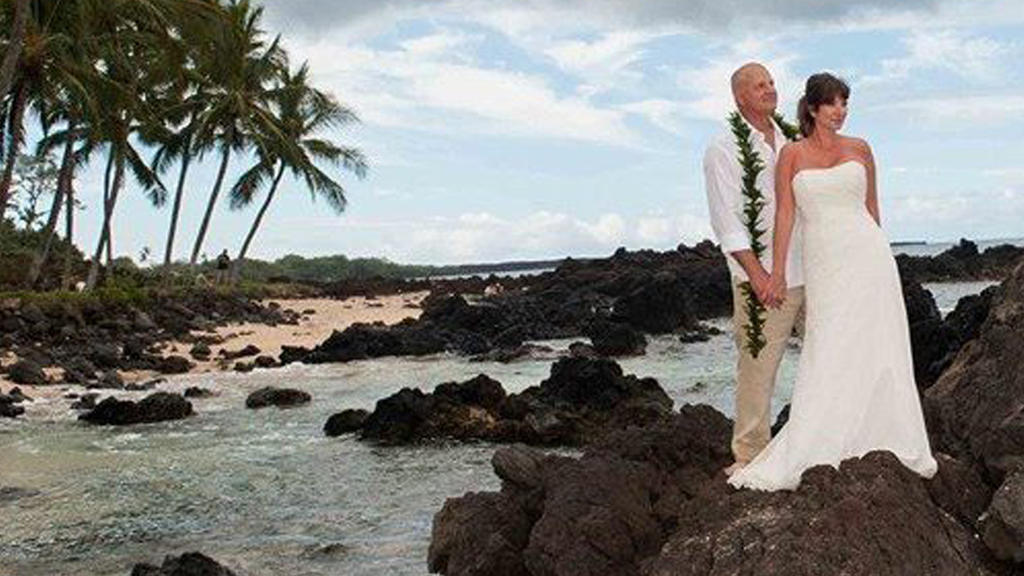 Nerissa Regnier in einem weißen Hochzeitskleid mit ihrem Ehemann am Strand