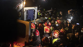 Rescue workers carry the body of 5-year-old Rayan and place it in an ambulance after it was retrieved from a hole in which he was stuck for several days, in the village of Ighran in Morocco's Chefchaouen province, Saturday, Feb. 5, 2022. The boy died and was pulled out Saturday night by rescuers after a lengthy operation that captivated global attention. (AP Photo/Mosa'ab Elshamy)
