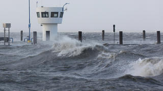 30.01.2022, Schleswig-Holstein, Dagebüll: Wellen der aufgepeitschten Nordsee drücken bei Sturm auf den Fähranleger Dagebüll. Foto: Bodo Marks//dpa +++ dpa-Bildfunk +++