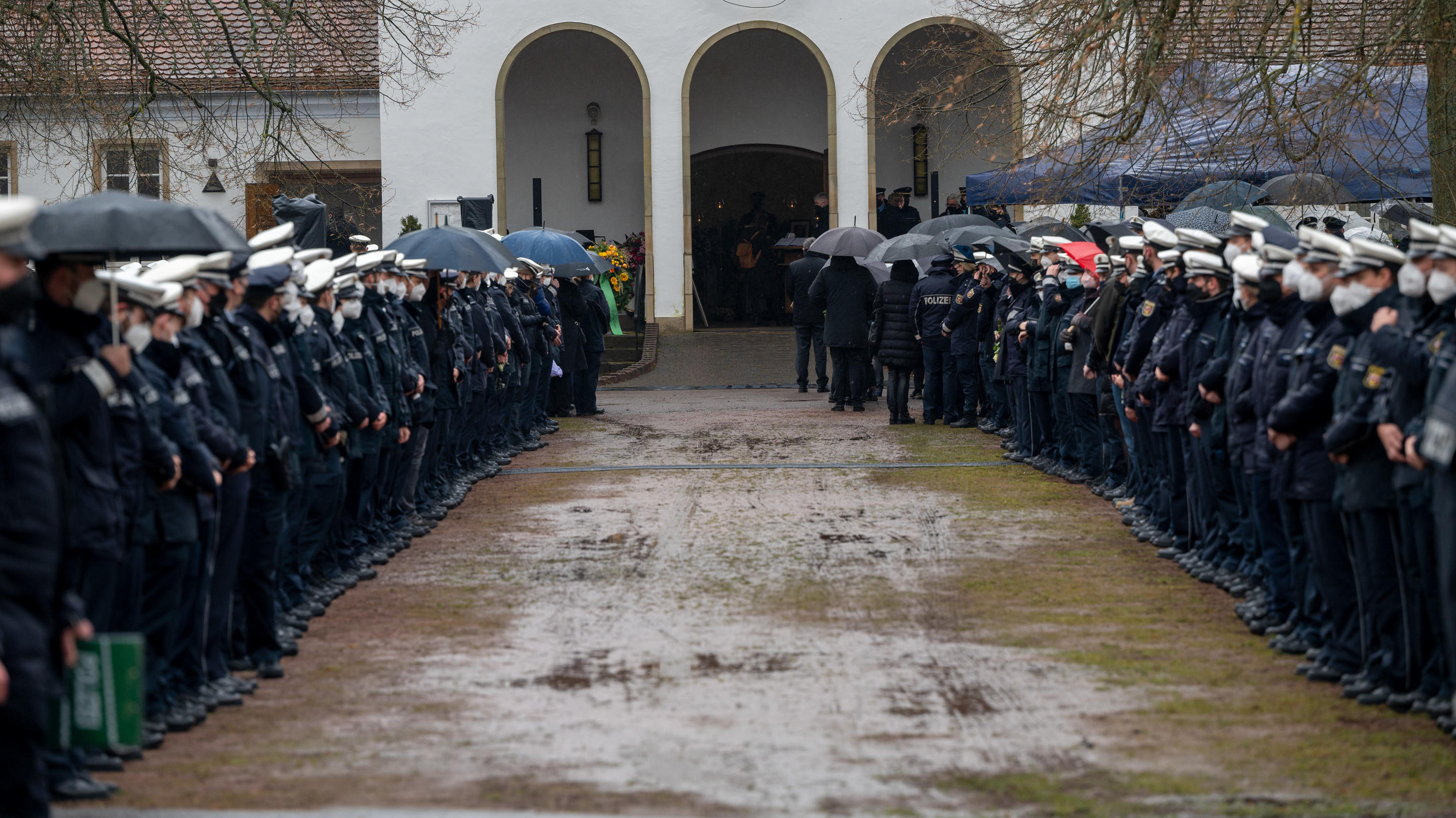 16.02.2022, Saarland, Homburg: Polizisten und Polizistinnen stehen an der Kirche Spalier beim Gedenkgottesdienst für eine getötete Polizistin. Nach der Bestattung eines ermordeten Polizisten wird nun auch seine getötete Kollegin beigesetzt. Der 29 Ja