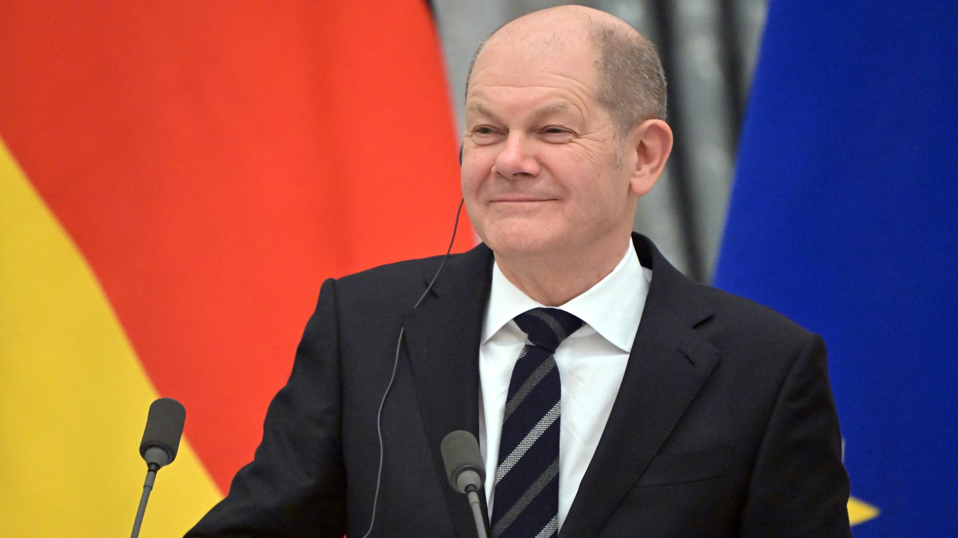 Der deutsche Bundeskanzler Olaf Scholz lächelt bei einer Pressekonferenz