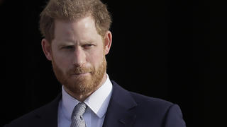 ARCHIV - 16.01.2020, Großbritannien, London: Der britische Prinz Harry steht in den Gärten des Buckingham Palast. Prinz Harry (37) will sich vor Gericht um Polizeischutz für seine Familie bei Besuchen in Großbritannien bemühen. Foto: Kirsty Wigglesworth/AP/dpa +++ dpa-Bildfunk +++