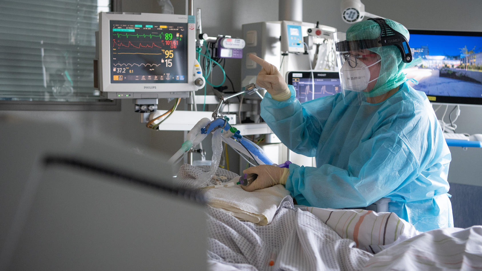 Eine Intensiv-Pflegerin versorgt einen schwer an Corona erkrankten Patienten auf der Intensivstation des Klinikums in Fulda. 