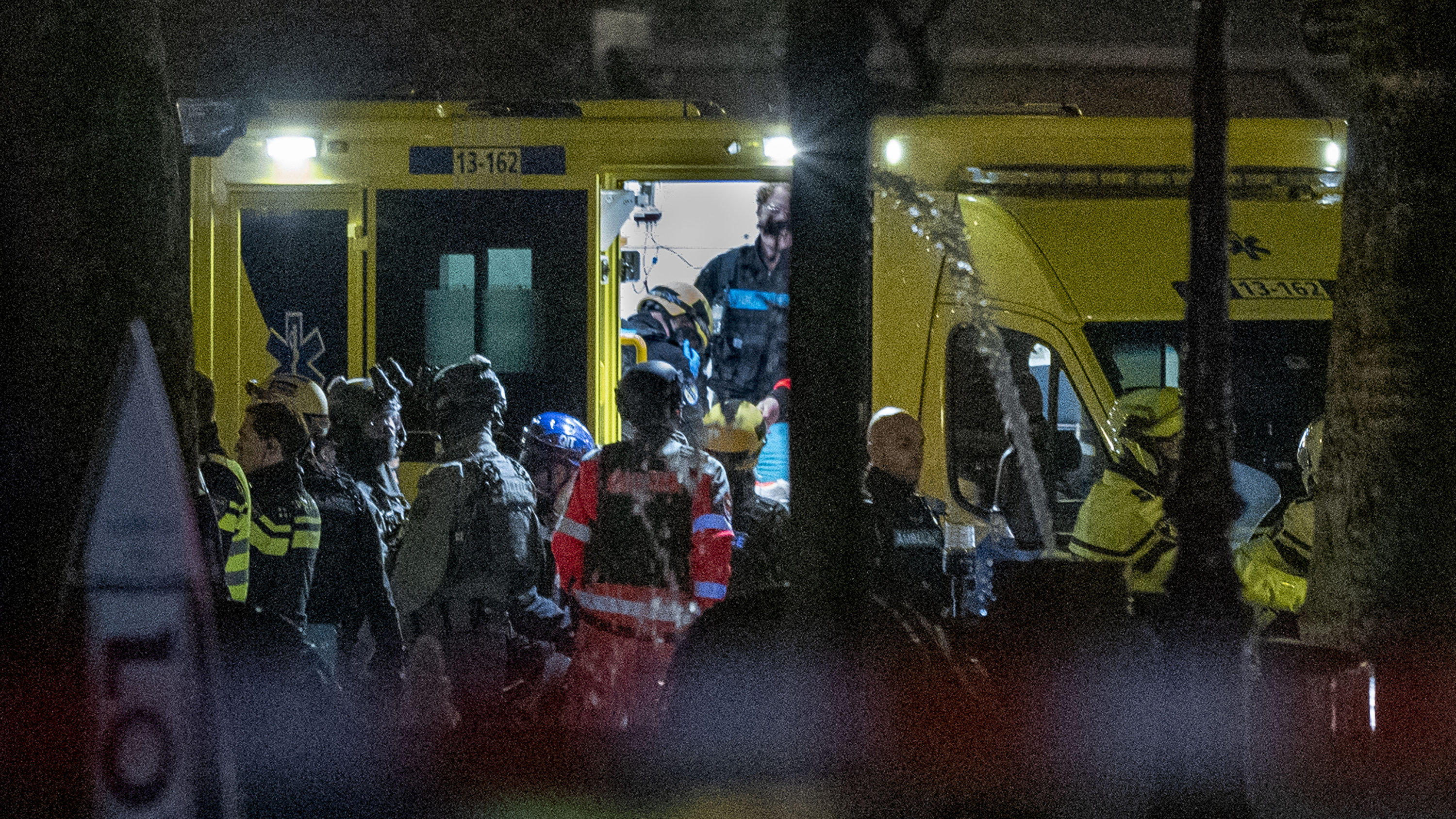 Police special intervention units and rescue workers are seen as the injured hostage taker is carried into an ambulance in Amsterdam, Netherlands, Tuesday, Feb. 22, 2022, where the armed person was holed up in the Apple Store with at least one hostag