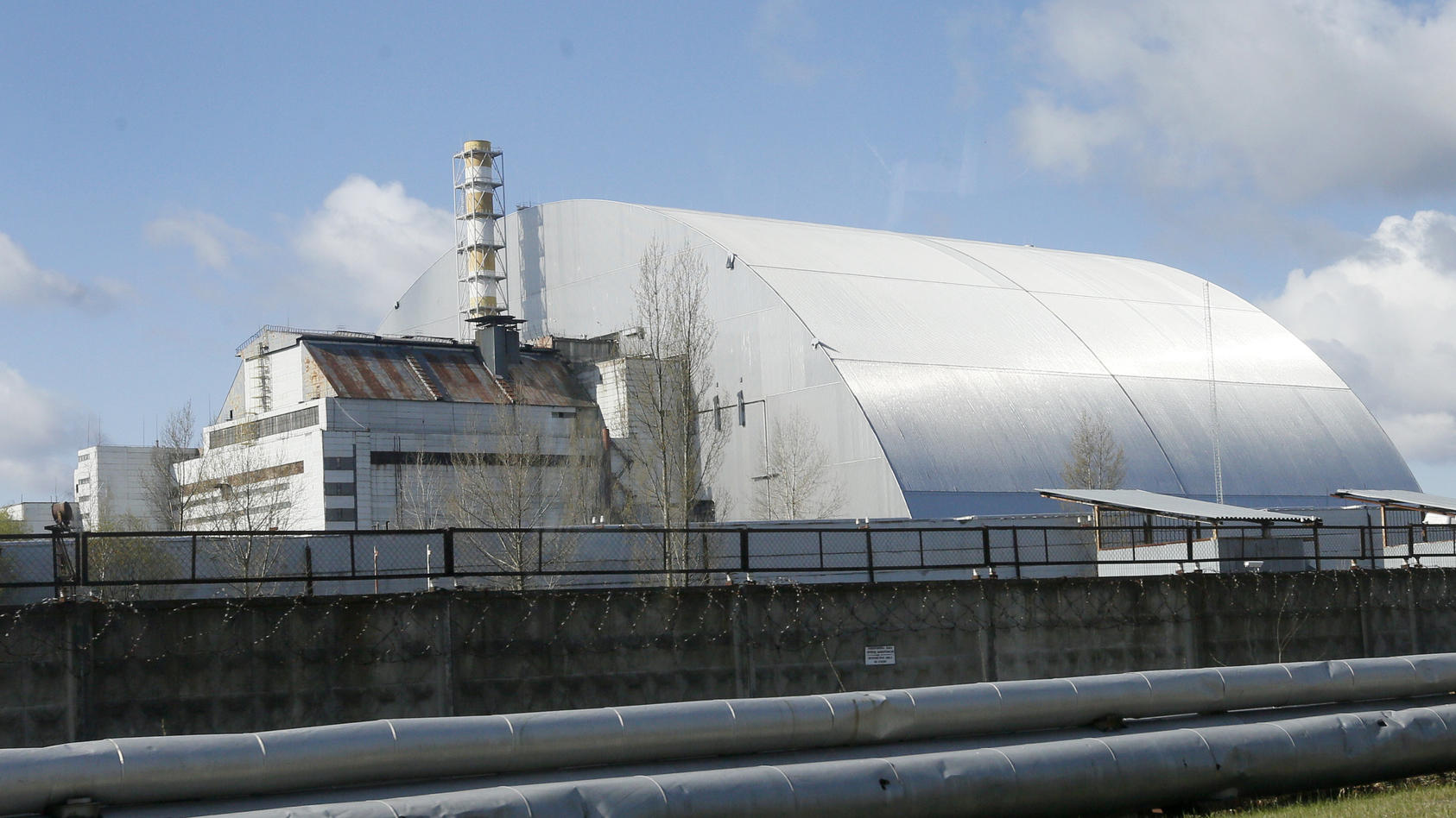 ARCHIV - 27.04.2021, Ukraine, Tschernobyl: Ein Schutzbau bedeckt den explodierten Reaktor im Kernkraftwerk Tschernobyl. Russische und ukrainische Truppen liefern sich nach Angaben des ukrainischen Präsidenten Wolodymyr Selenskyj am Donnerstag (24.02.