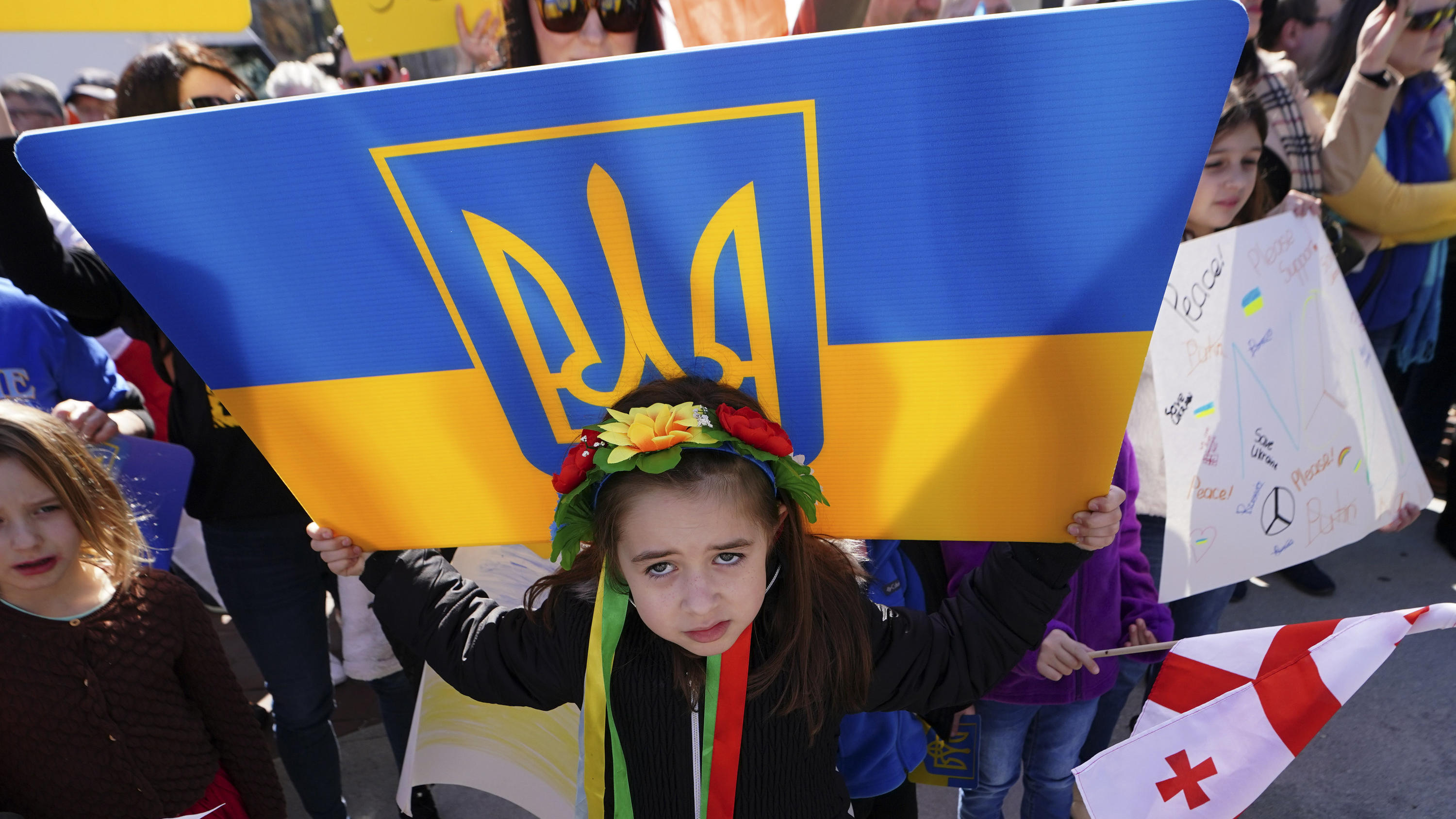 Six-year-old Grace Mokiienko holds sign during a rally to show support for Ukraine Saturday, Feb. 26, 2022, in Atlanta. Grace's father is a Ukrainian immigrant and still has family in Ukraine. Ukrainians in the United States are praying for friends a