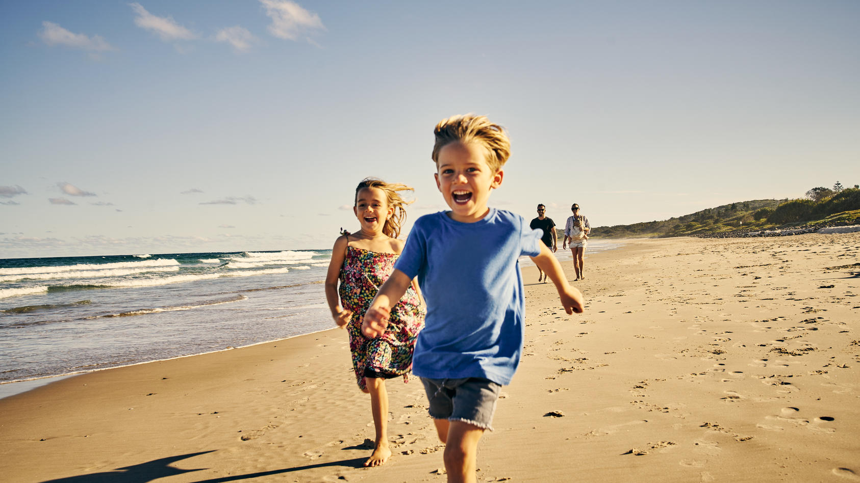 Kinder laufen glücklich am Strand entlang.