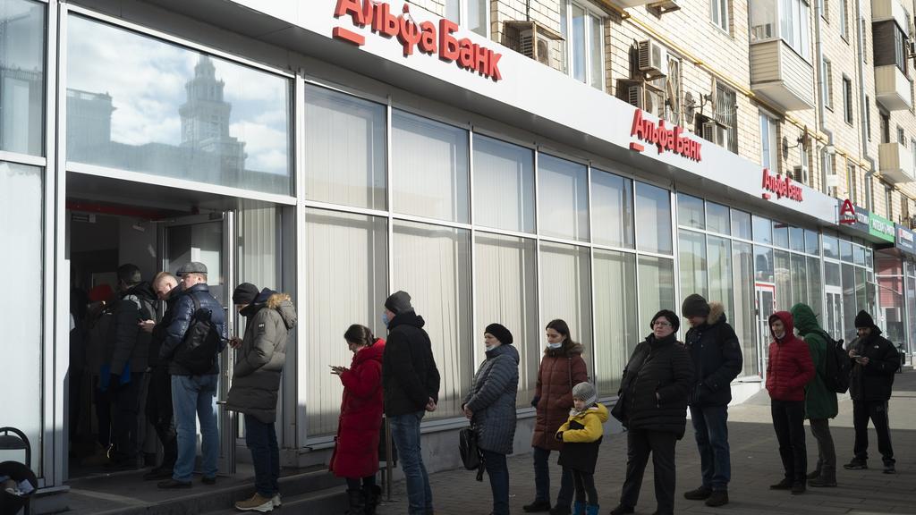 27.02.2022, Russland, Moskau: Menschen stehen in einer Schlange, um Geld von einem Geldautomaten der Alfa Bank abzuheben. Russische Truppen haben den erwarteten Angriff auf die Ukraine gestartet. Foto: Victor Berzkin/AP/dpa +++ dpa-Bildfunk +++
