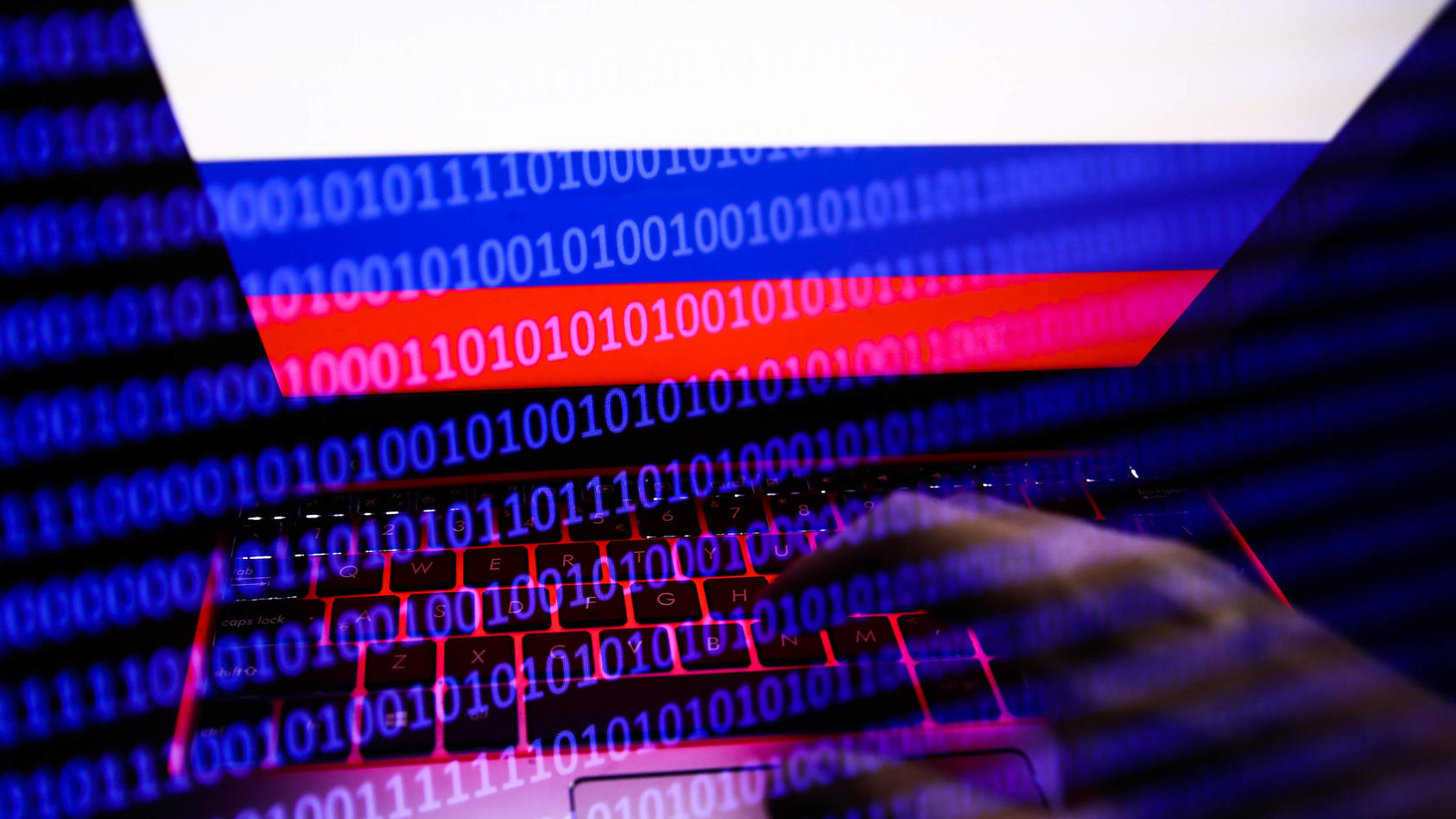 Russia, Ukraine And Internet Hacking Photo Illustrtions Russian flag displayed on a laptop screen and binary code code displayed on a screen are seen in this multiple exposure illustration photo taken in Krakow, Poland on February 16, 2022. Photo ill
