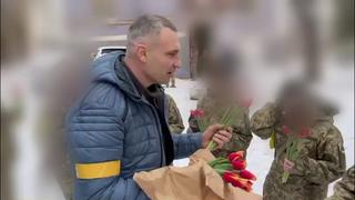 Vitali Klitschko, Bürgermeister der ukrainischen Hauptstadt Kiew, verteilt Tulpen an Soldatinnen.