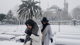 People, with the Sultanahmet Mosque, known as the Blue Mosque in the background, walk during a snow storm in Istanbul, Turkey March 11, 2022. REUTERS/Dilara Senkaya