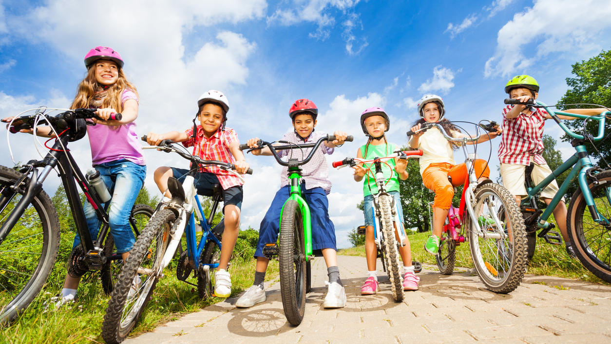 Gruppe Kinder mit Helmen auf ihren Fahrrädern