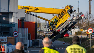 21.03.2022, Bayern, Pentling: Ein Autokran ist mit seinem Ausleger auf das Dach eines Supermarktes gestürzt. Verletzt wurde bei dem Unfall nach ersten Erkenntnissen der Polizei niemand. Das Gebäude sei evakuiert worden. Foto: Armin Weigel/dpa +++ dpa-Bildfunk +++