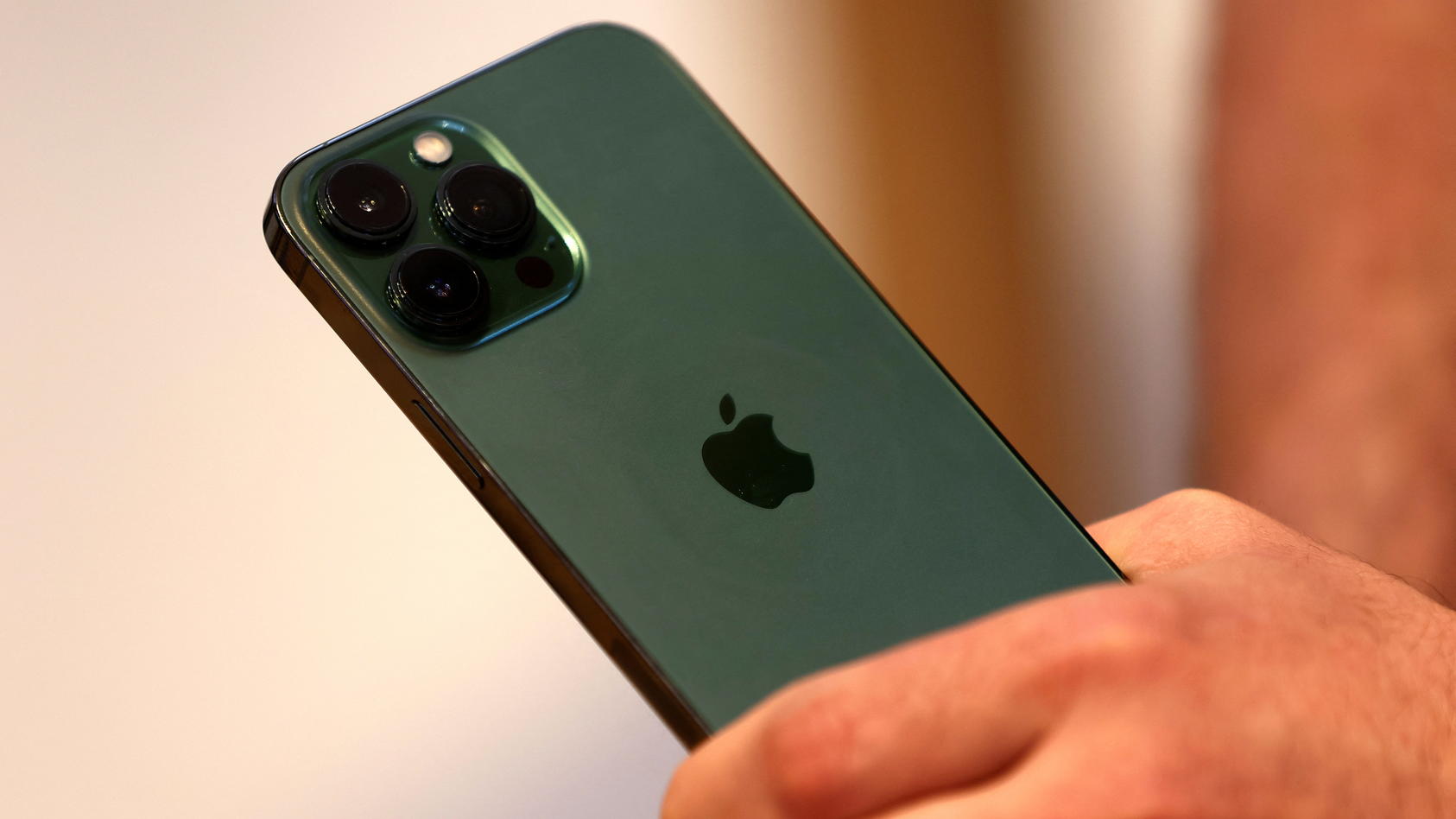 A customers holds the new green colour Apple iPhone 13 pro shortly after it went on sale inside the Apple Store on 5th Avenue in Manhattan in New York City, New York, U.S., March 18, 2022. REUTERS/Mike Segar