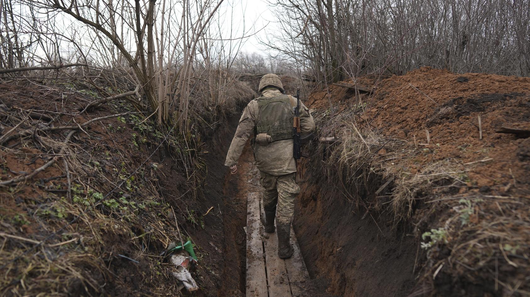 23.02.2022, Ukraine, Svitlodarsk: Ein ukrainischer Soldat geht durch einen Graben an der Trennlinie zwischen dem von der Ukraine und dem von pro-russischen Separatisten gehaltenen Gebiet in der Nähe von Svitlodarsk in der Ostukraine. Die Ukraine rüst