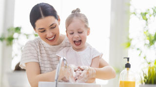 Mutter und Tochter haben Spaß beim Händewaschen
