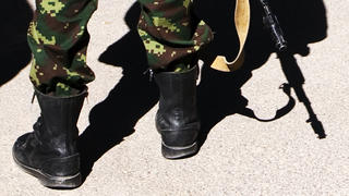 Close Schuhe und Gewehr eines Soldaten