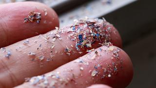 Close up side shot of microplastics lay on people hand.Concept of water pollution and global warming. Climate change idea.