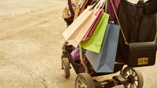 Outdoor crop shot of baby carriage with shopping bags.