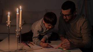 Vater und Sohn bei Kerzenlicht