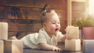 Baby spielt mit Holzspielzeug