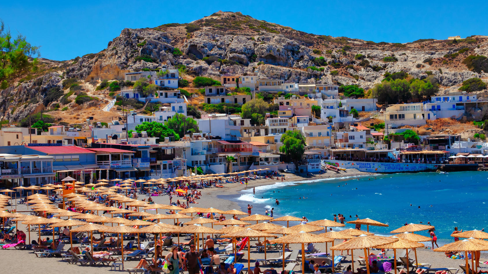 Urlauber entspannen am Strand von Matala auf der griechischen Insel Kreta