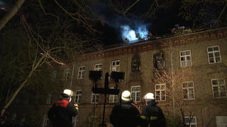 12.04.2022, Sachsen, Leipzig: Feuerwehrleute stehen bei einem Brand in einem Mehrfamilienhaus. Nach einem Brand in einem Mehrfamilienhaus in Hamburg-Rotherbaum ist in der Nacht zum Dienstag ein Mensch gestorben. Wie die Polizei mitteilte, wurde die Person aus dem brennenden Haus gerettet und reanimiert, starb jedoch kurze Zeit später. Foto: Steven Hutchings/TNN/dpa +++ dpa-Bildfunk +++