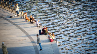 23.03.2022, Berlin: Menschen genießen den Sonnenschein am Ufer der Spree im Regierungsviertel. Foto: Kay Nietfeld/dpa +++ dpa-Bildfunk +++