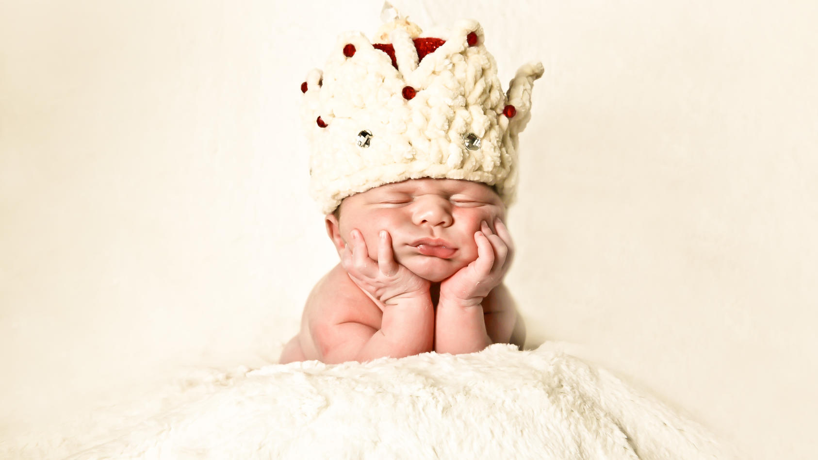 Ein Baby beim Fotoshooting mit Krone.