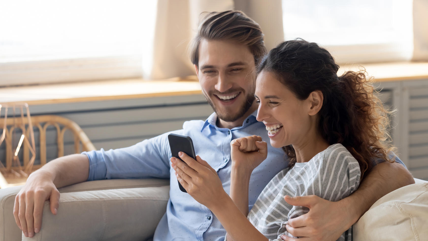 Ein Paar freut sich über den Ankaufswert des gebrauchten Handys.